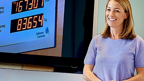 Woman speaking in front of a projection of a presentation