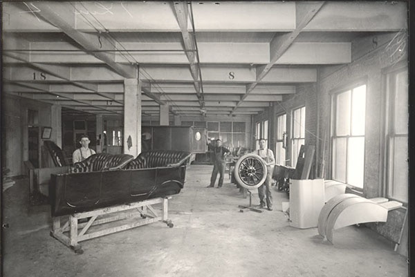 Johnson employees crafting a sedan (foreground) and truck cab (background), 1907