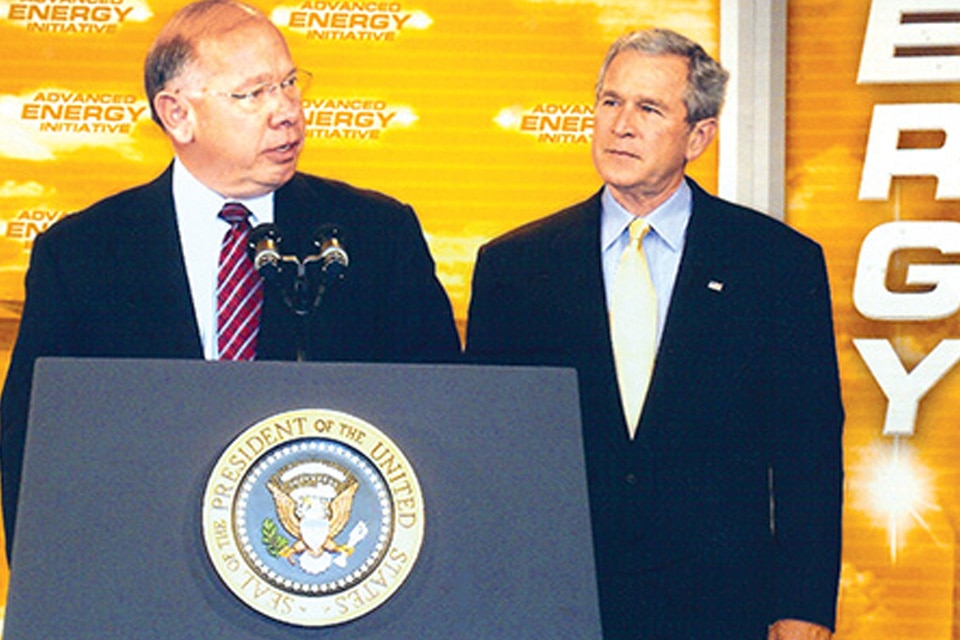US President George W. Bush, and Johnson Controls CEO John Barth speaking at a podium