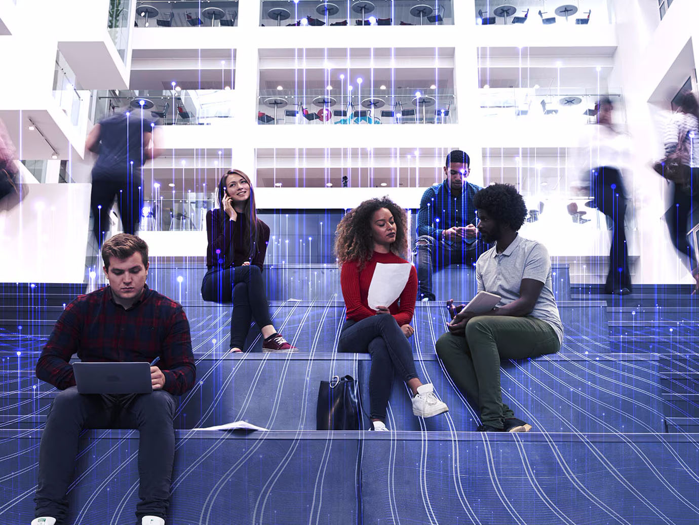 Group of university students sitting on the stairs and working