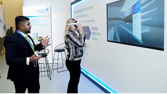 Man explaining to a woman wearing a VR headset