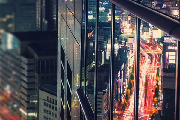 Reflection of traffic at night in the window of a skyscraper