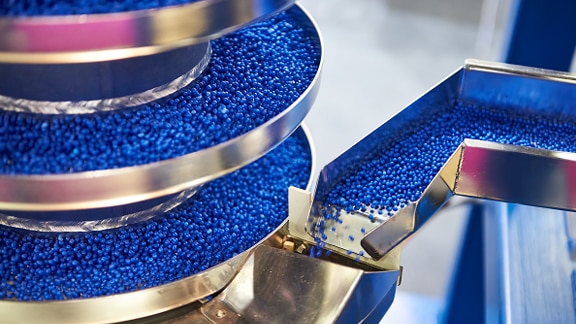 A conveyor belt and manufacturing equipment sorting blue plastic granules