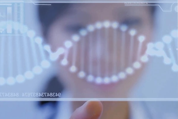 DNA strand on a screen with a blurred person in the background
