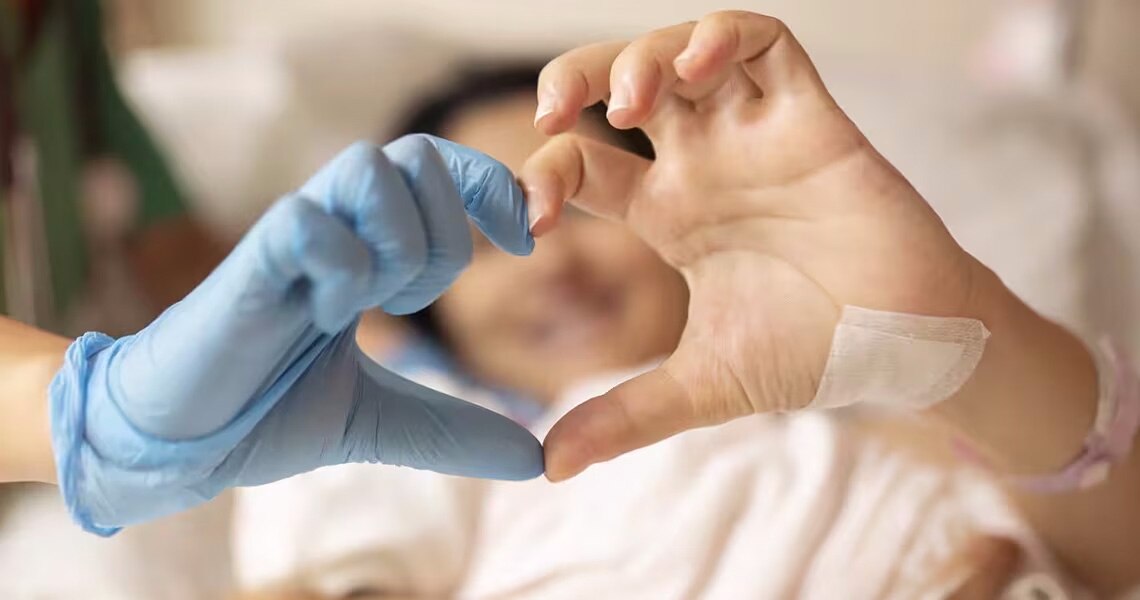 A doctor and a patient joining their hands to form a heart