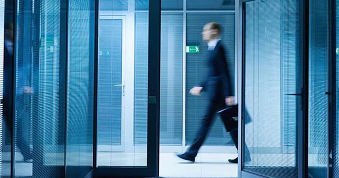 Motion-blur shot of a man walking through an office hallway