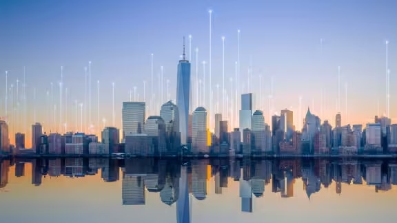 Waterfront skyline of a city, overlaid with a graphic of transmission nodes