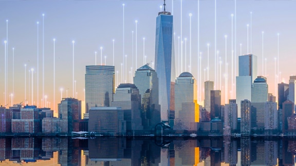 Waterfront skyline of a city, overlaid with a graphic of transmission nodes