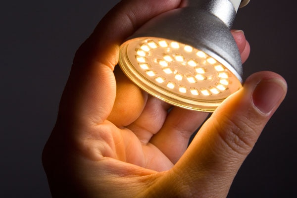 Close-up of a person's hand adjusting a study lamp