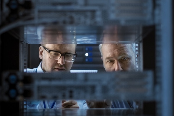Two employees inspecting a data server rack