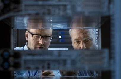 Two men inspecting a data server rack