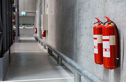 Fire extinguishers on a wall in a hallway