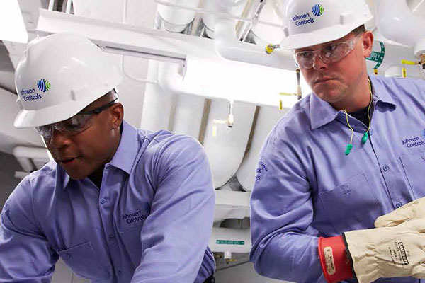 Two Johnson Controls maintenance workers wearing safety helmets