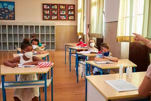 Children in face masks sitting at their desks in a classroom