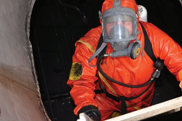 A man in an orange biohazard suit