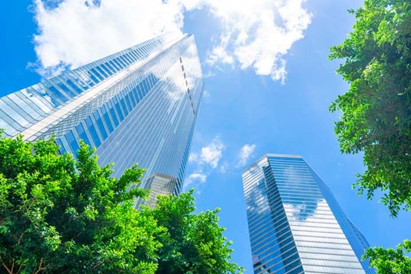 Low-angle view of high-rise buildings surrounded by greenery
